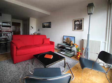 Le salon TV donnant sur le jardin, des étagère avec la Chaine Hi-Fi